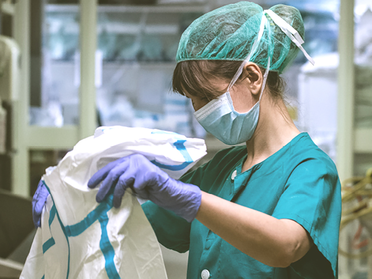 Enfermera se prepara para ponerse el equipo de protección (EPI) contra COVID 19